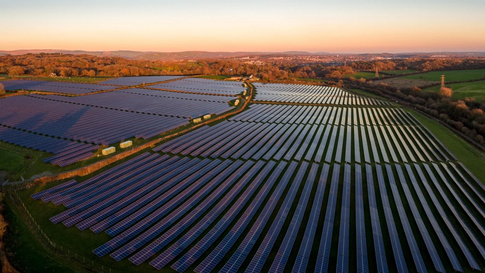 Luftaufnahme eines großen Solarparks in der Abenddämmerung